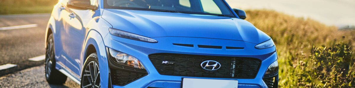Blauer Hyundai Kona N Line in schräger Frontansicht am Straßenrand