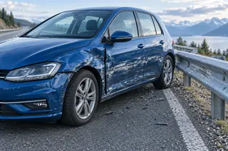 Blauer Unfallwagen mit seitlichen Schleifspuren neben einer Leitplanke
